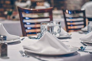 Sophisticated restaurant table setting with crystal glassware and white napkins, perfect for fine dining experiences. HD wallpaper