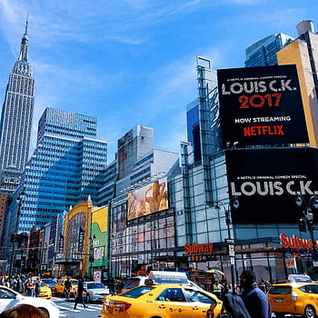 A vibrant scene featuring New York City's skyscrapers and taxis under a bright blue sky. HD phone wallpaper