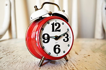 Close-up of vintage red alarm clock on rustic wood surface, indoors. HD wallpaper
