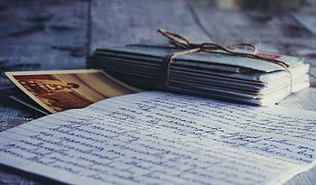 Stack of vintage letters and graphs tied with string on a rustic wooden table. HD wallpaper