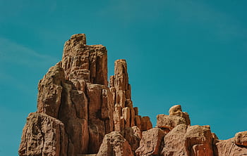 Dramatic sandstone rock formations against a vivid blue sky, capturing natural beauty. HD wallpaper
