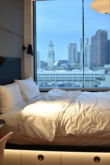 Modern hotel room overlooking Boston skyline, featuring luxury bedding. HD phone wallpaper