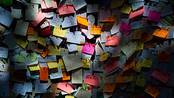 Various colorful sticky notes pinned on a board creating a vibrant display. HD wallpaper