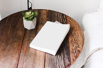 Close-up of a wooden bedside table with a succulent plant and a book, showcasing cozy home decor. HD wallpaper