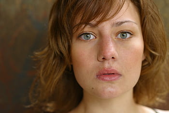 A close-up portrait capturing a young woman's natural beauty with a serious expression. HD wallpaper