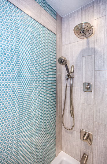 Elegant shower design featuring blue mosaic tiles and stainless steel fixtures. HD phone wallpaper
