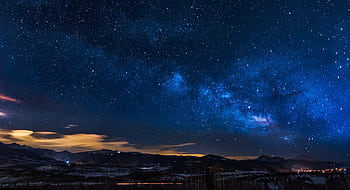 A breathtaking view of the Milky Way galaxy illuminating the night sky over mountains. HD wallpaper
