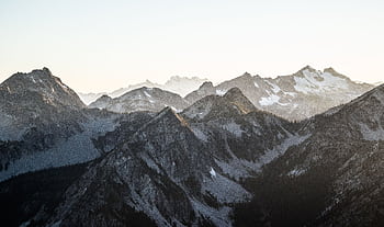 Breathtaking view of snow-covered mountains during dawn, capturing calm nature and winter beauty. HD wallpaper