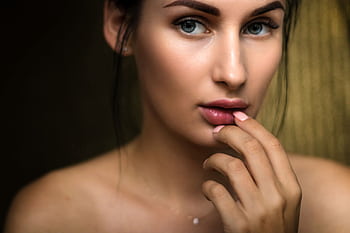 Close-up portrait capturing a woman's natural beauty with soft lighting and a thoughtful expression. HD wallpaper