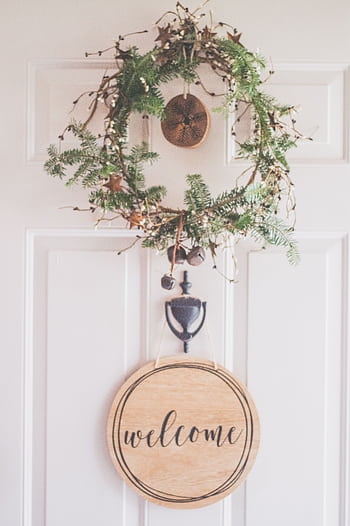 A rustic wreath with a welcome sign adorns a white front door, creating a cozy decor feel. HD phone wallpaper