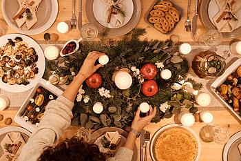 A top-down view of a festive holiday table setting with candles and decorations, perfect for Christmas or New Year's dinner. HD wallpaper