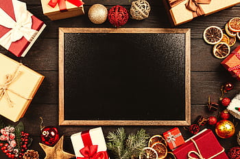 Top-down view of a blackboard surrounded by Christmas gifts and decorations with space for text. HD wallpaper