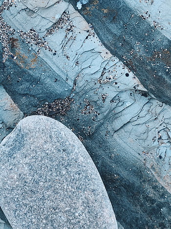 Detailed view of a textured rock surface with sand, showcasing natural patterns and earthy tones. HD phone wallpaper