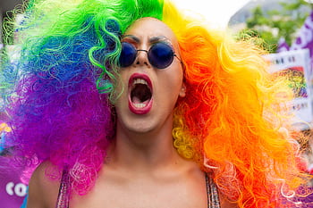 Colorful participant with rainbow wig and sunglasses at Brussels Pride Parade. HD wallpaper