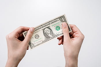 Hands holding a one dollar bill, depicting currency and finance closely. HD wallpaper