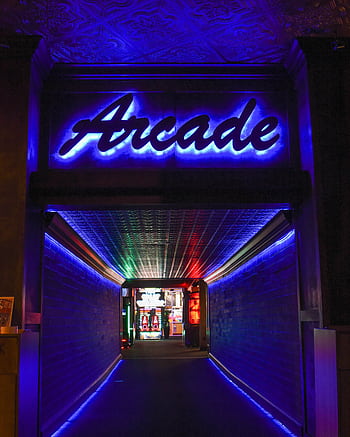 Vibrant neon light hallway leading to retro arcade gameplay area. HD phone wallpaper