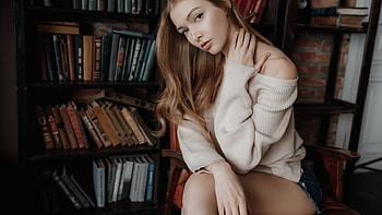 Pretty brunette with red highlights, off shoulder sweater, denim shorts, sitting by book shelves, brunette, red highlights, library setting HD wallpaper