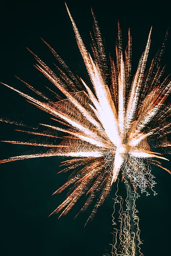 Captivating long exposure of fireworks illuminating the night sky with vibrant colors. HD phone wallpaper