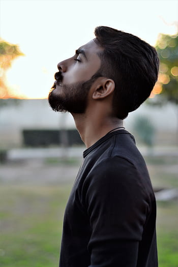 Side view portrait of a bearded man gazing upwards in an outdoor setting with blurred background. HD phone wallpaper