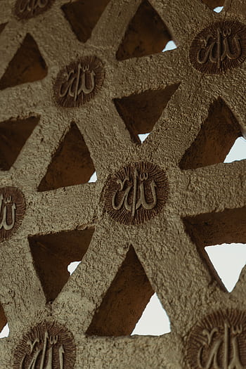 Intricate Islamic geometric design with Arabic calligraphy on a textured wall. HD phone wallpaper