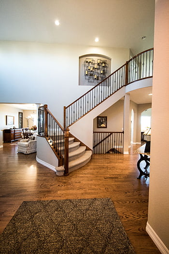 Spacious modern interior showcasing a stylish wooden staircase and elegant decor. HD phone wallpaper
