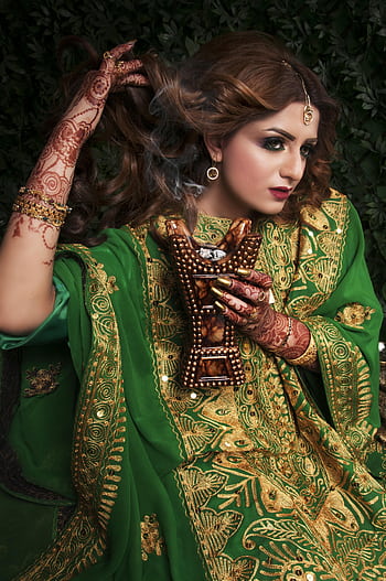 Portrait of a woman in vibrant green traditional attire adorned with henna and jewelry, exuding elegance. HD phone wallpaper