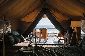 A luxurious tent setup with a view of the ocean, perfect for a peaceful getaway. HD wallpaper