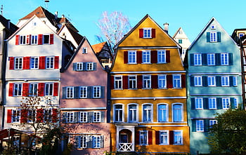 Vibrant facades of traditional houses in Tübingen's historic center, under a clear daytime sky. HD wallpaper