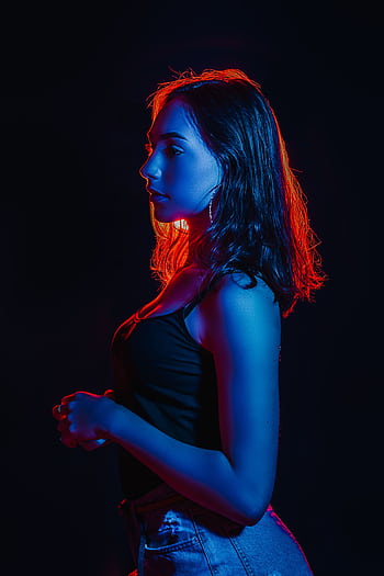 Blue and red lighting highlights a woman posing in a dark studio setting. HD phone wallpaper