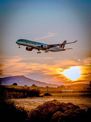 A passenger airplane flying over a scenic landscape at sunset, capturing the aviation spirit. HD phone wallpaper