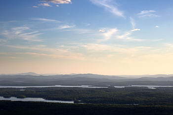 A tranquil view of mountains and river under a serene sky during dawn. HD wallpaper