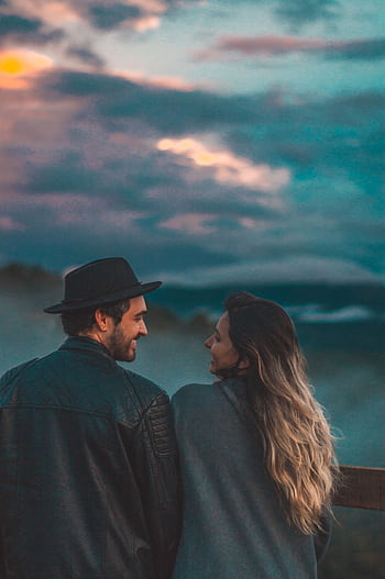 A couple gazing at the sunset, surrounded by beautiful clouds and nature. HD phone wallpaper
