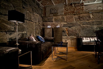 Elegant living room featuring rustic stone walls and modern furniture design. HD wallpaper