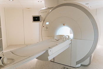 A state-of-the-art MRI scanner in a well-lit hospital room, ready for patient use. HD wallpaper