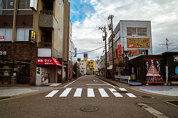 Vibrant urban street in Japan with buildings and a zebra crossing in view. HD wallpaper