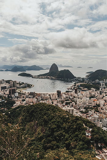 Stunning aerial view of Rio de Janeiro's cityscape with Sugarloaf Mountain in Brazil under a cloudy sky. HD phone wallpaper