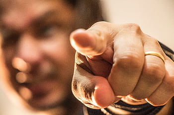 Dynamic close-up of a hand pointing forward with a blurred background. HD wallpaper