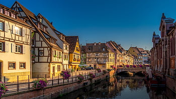 Scenic view of Colmar, France featuring que half-timbered houses and a tranquil canal at sunset. HD wallpaper