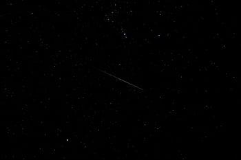 A serene view of a shooting star across a starry sky, perfect for astronomy lovers. HD wallpaper