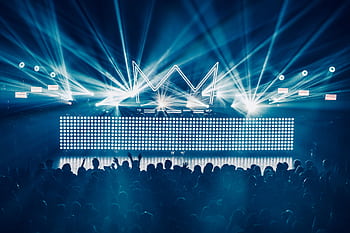 An electrifying concert atmosphere featuring dynamic laser lights and a vibrant crowd enjoying live music. HD wallpaper