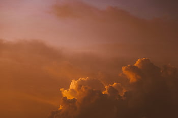 A tranquil cloudscape during sunset with warm orange and purple tones, perfect for a calming mood. HD wallpaper