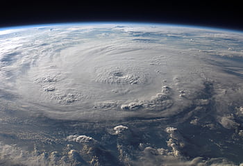 A stunning aerial view of Earth with a massive swirling hurricane, highlighting meteorological beauty. HD wallpaper