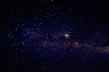 A serene view of a crescent moon nestled in a star-filled night sky with the Milky Way. HD wallpaper