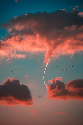 Dramatic sunset sky with vibrant clouds and contrails creating a scenic view. HD phone wallpaper