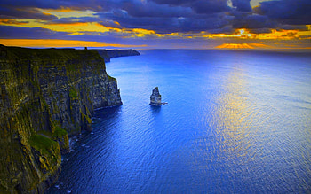 Stormy sunset, nature, cliff, ocean, stormy, sunset, blue, graphy, orange, rocks, aerial, clouds, sky HD wallpaper