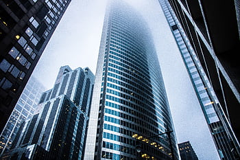 Dramatic view of modern skyscrapers shrouded in fog in an urban cityscape. HD wallpaper