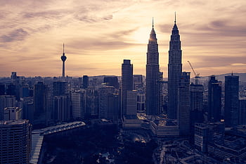 Explore Kuala Lumpur's skyline featuring the iconic Petronas Towers at sunset. Perfect for travel and architecture enthusiasts. HD wallpaper