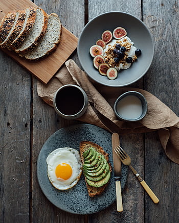 Healthy breakfast with avocado toast, eggs, and yogurt with figs and berries on a wooden table. HD phone wallpaper
