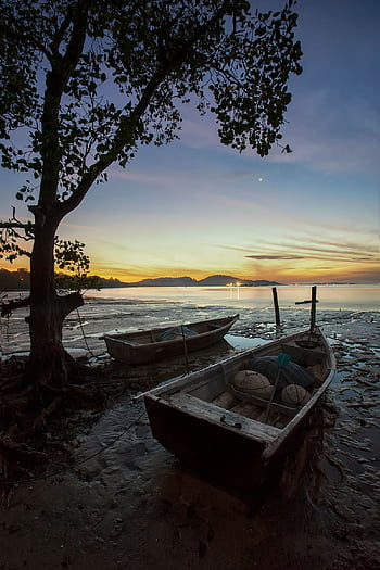 A serene scene of wooden boats at the shore during twilight, highlighting calm waters and a pastel sky. HD phone wallpaper