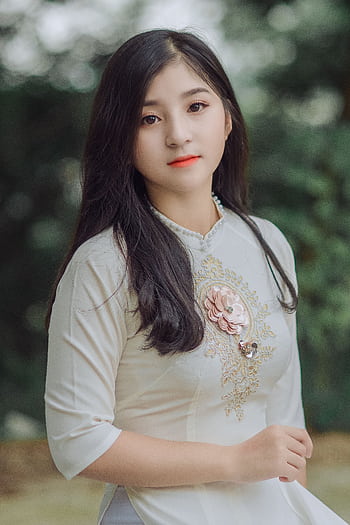A graceful portrait of a woman in a traditional embroidered dress, outdoors. HD phone wallpaper